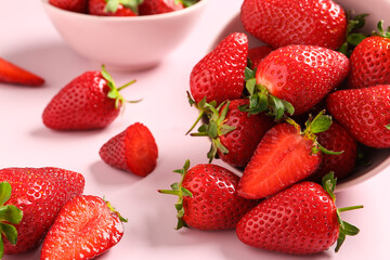 Bowls with sweet fresh strawberries on pink background, closeup