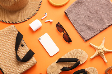 Composition with modern mobile phone, earphones and beach accessories on color background