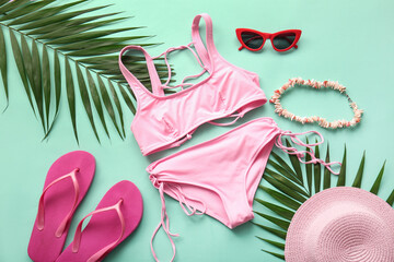 Composition with stylish female swimsuit, accessories and palm leaves on color background