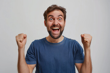 Photo of an excited man wearing a casual t-shirt while raising fists up on a white background - Powered by Adobe