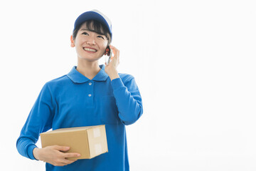 スマホで通話する配達員の女性（配達・軽貨物ドライバー・宅配・配達員・宅急便）
