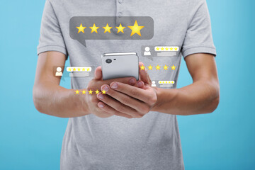 Man looking through service feedbacks with smartphone on light blue background, closeup. Reviews...
