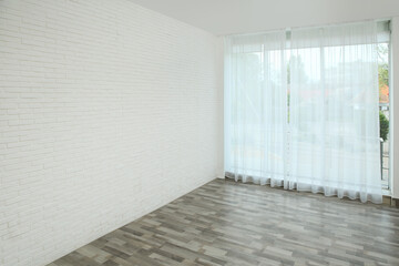 Empty room with white brick wall and large window