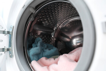 Modern washing machine drum with laundry, closeup