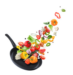 Frying pan and different vegetables in air on white background