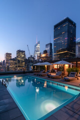 Fototapeta premium A chic city rooftop pool oasis with lounge chairs, umbrellas, and panoramic skyline views, offering a stylish and luxurious escape from the urban hustle.