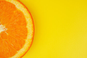 Summer fruit background concept, orange slice close up on yellow background