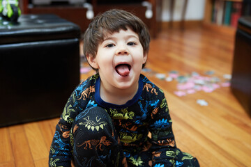 Expressive young boy in pajamas making faces - Powered by Adobe