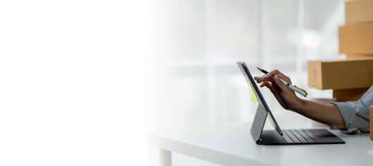 A person is using a tablet to write on a white background