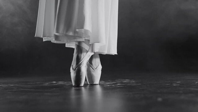 Ballerina feet in pointe shoes. Legs of professional dancer shows classic pas