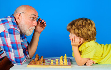 Grandson playing chess with grandpa. Games and activities for children. Grandfather teaching...