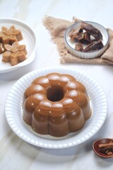 Traditional dessert brown sugar jelly pudding  called agar-agar gula merah on white plate
