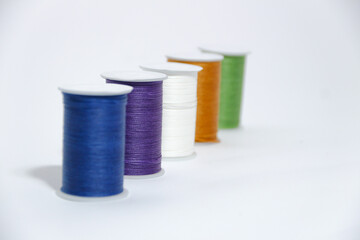 Spool of sewing thread, isolated on white background. Colored yarns used by factories in the clothing industry. Threads wound on the spool. Colored reels