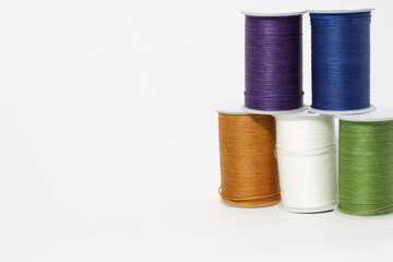 Spool of sewing thread, isolated on white background. Colored yarns used by factories in the clothing industry. Threads wound on the spool. Colored reels