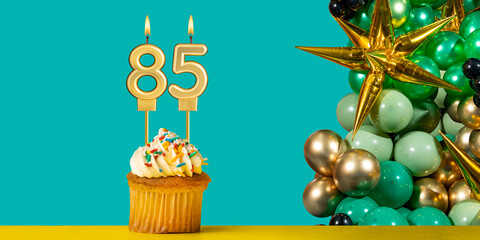 Birthday candle number 85 - Cupcake with decoration on a green background