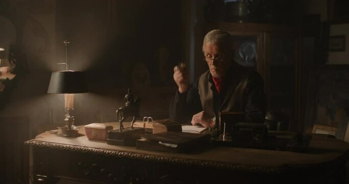 Old elegant watchmaker in his office.
