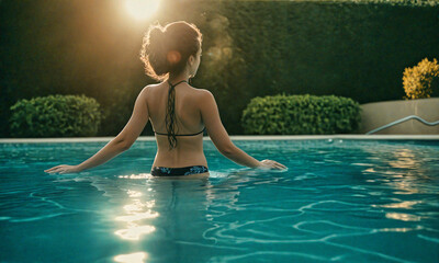 At the Poolside: A Woman Gazing at the Sunset from Behind