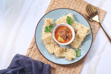 Roti Jala or Lace pancake is Indonesian traditional food served with curry dishes

