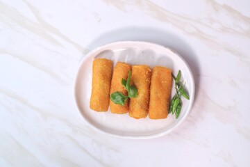 landscape view of vegetable risole on white plate with cayenne pepper