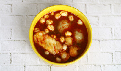 Baso Aci with spicy sauce. Baso aci is made from tapioca flour mixed with seasoning and served with tofu, pilus, lime, and fried bakso or meatballs. Indonesian street food.