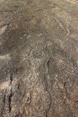 Details of sand stone texture, closeup shot of rock surface with vignette at cover and bright spot at centre, idea for background or backdrop.