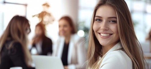 smiling business women in a meeting at the office, white bright background, laptop and coffee on the table, blurred people sitting around the conference room