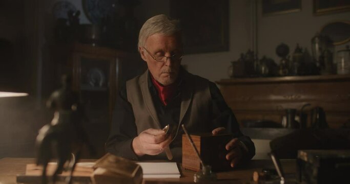 Old man evaluating vintage objects.