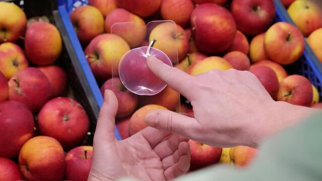 Woman uses nitrate tester when choosing fruits and vegetables in supermarket before buying. Futuristic non-contact measuring device in human hand scanning apples in market. Screen shows  bad result.