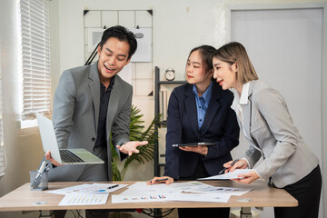 Group of Asian business men and women sitting and looking at documents at the office.