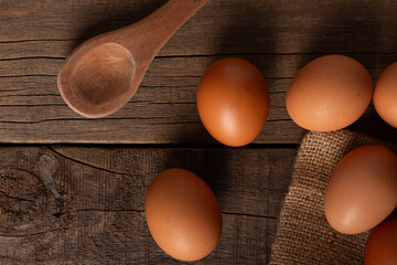 Brown eggs with wooden spoon on a wooden table