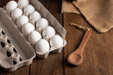 Package of white eggs on wooden table