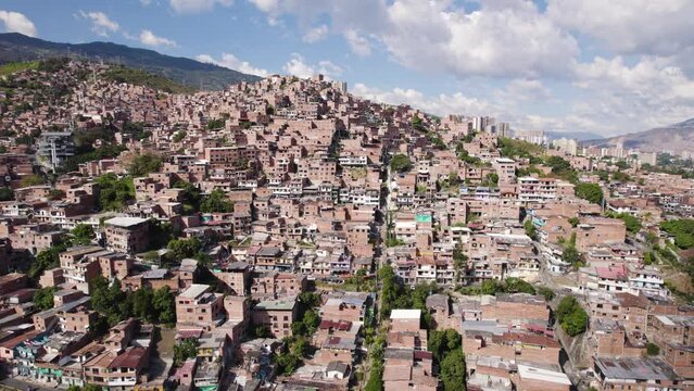 Multi family homes crowd mountainside favela in Medellin Colombia, aerial establish