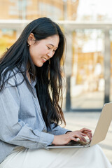 Smiling young businesswoman using laptop