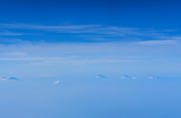 view of the bright blue sky and mountains on the island of Java from the plane window, blue sky with clouds, See Through Plane Window With Blue Sky And Clouds Outside, travel trip over Java island