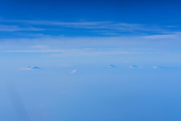 view of the bright blue sky and mountains on the island of Java from the plane window, blue sky with clouds, See Through Plane Window With Blue Sky And Clouds Outside, travel trip over Java island