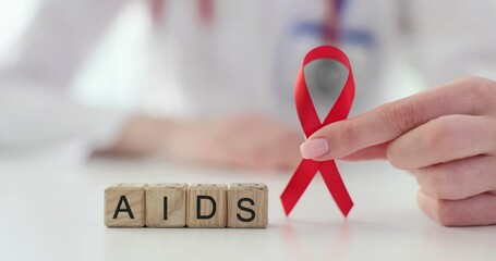 Prevention of HIV infection among health care workers and doctor holds red ribbon