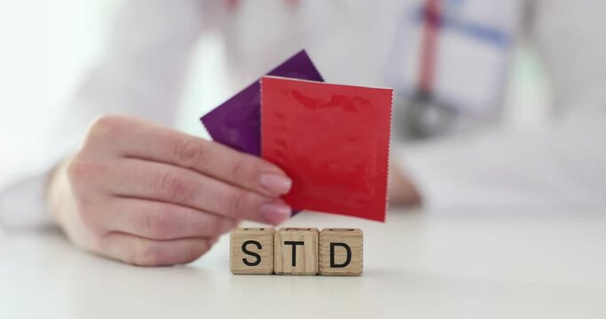 Doctor is holding condoms and word STD closeup