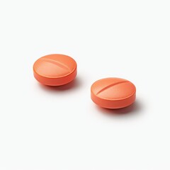 Two orange ibuprofen pills rest on a white surface