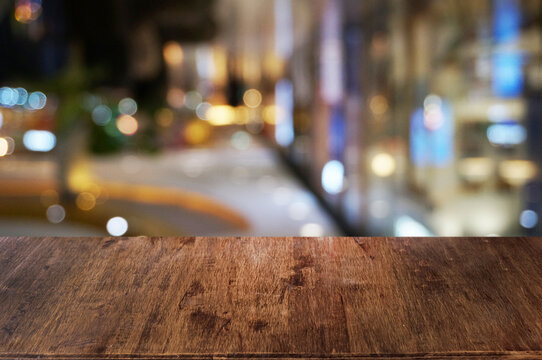 Empty dark wooden table in front of abstract blurred boken bankground of restaurant. Can used for display or montage your products. Mock up for space.