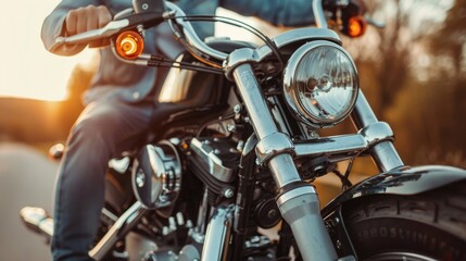 Close-up of a rider on a classic motorcycle, cruising during sunset with chrome details and blurred background.