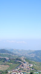 Clear blue sky: With a touch of haze in the distance, suggesting a mountainous region.