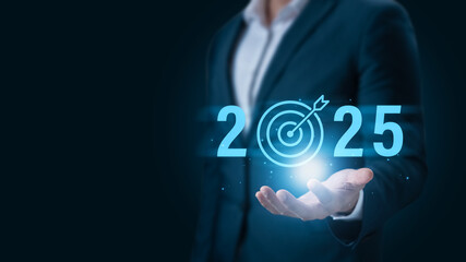 Set goals for 2025, businessman holds text 2025 with arrow target, implementation of business goals...