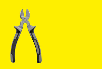 Industrial pliers, diagonal cutting tool for wire and cable. Yellow background with copy space,...