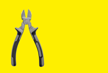 Industrial pliers, diagonal cutting tool for wire and cable. Yellow background with copy space, promotion banner for mechanical equipment. Insulated handle, steel construction and repair instrument.