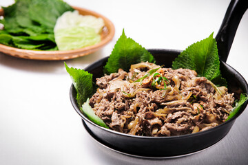 검정프라이팬에 깻잎과 맛있는 불고기가 있다.