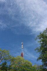 Fototapeta premium Signal tower on blue sky background. Telecommunication tower