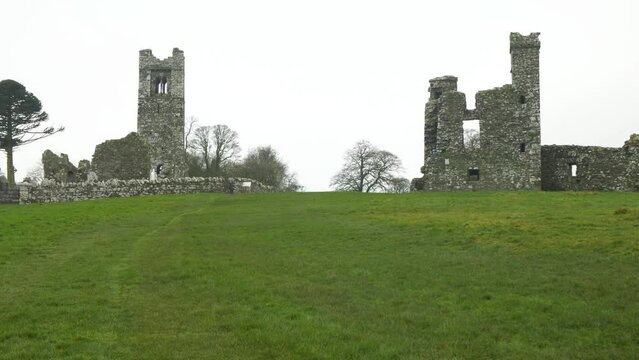 Historic ruins of St Erc's church and college on the Hill of Slane, Ireland, with lush green field in foreground