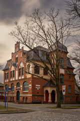 Dramatischer Wolkenhimmel &uuml;ber dem denkmalgesch&uuml;tzten Alten Rathaus in Hennigsdorf bei Berlin im Winter, Ansicht von Nordosten - Inschriften wurden teilweise entfernt