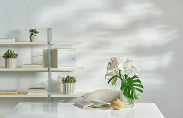 Decorative white room, table chair and working style with vase of plant and bookshelf.