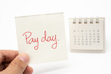 For payday concept. Desk calendar and paper note in isolated background. Business, finance, savings...